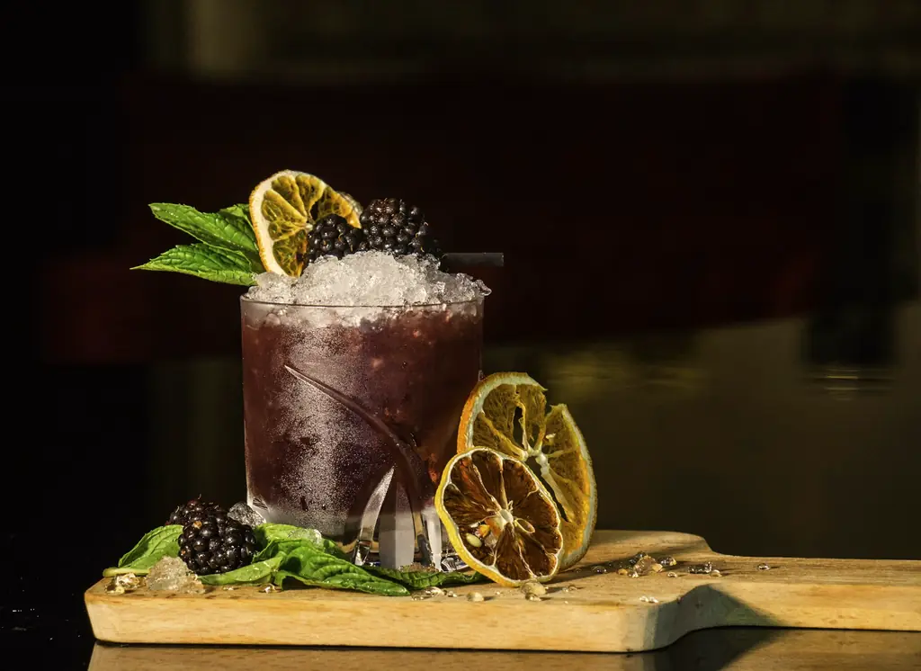 Dark rum cocktail with orange garnish